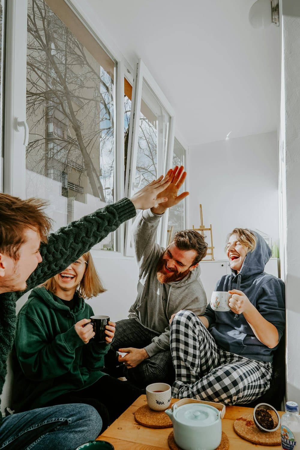 Four friends celebrating a finished week with a high five