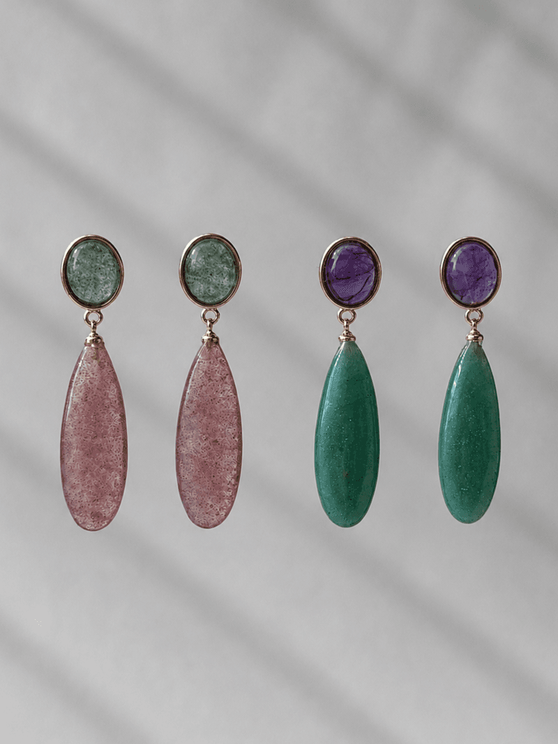 Two pairs of drop earrings side by side: green bezels above pink speckled teardrops, and purple bezels above green teardrops