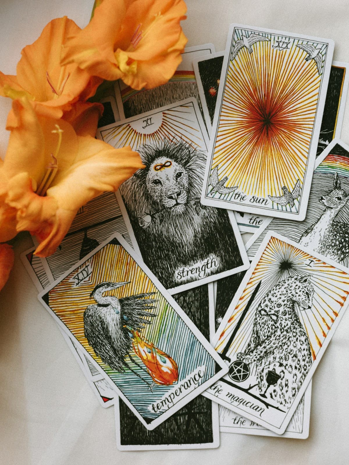 Cartas de tarot extendidas sobre una mesa con flores naranjas