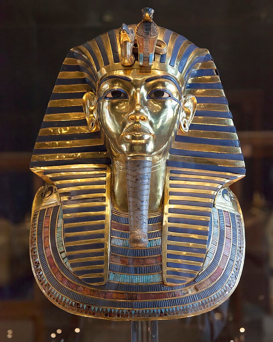 The gold funerary mask of Tutankhamun with blue striped headdress, seen from the front in the Egyptian Museum in Cairo